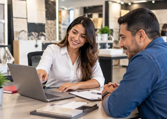 Vendedora mostrando una cotización a un cliente en un showroom